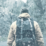 man with his backpack on a snow