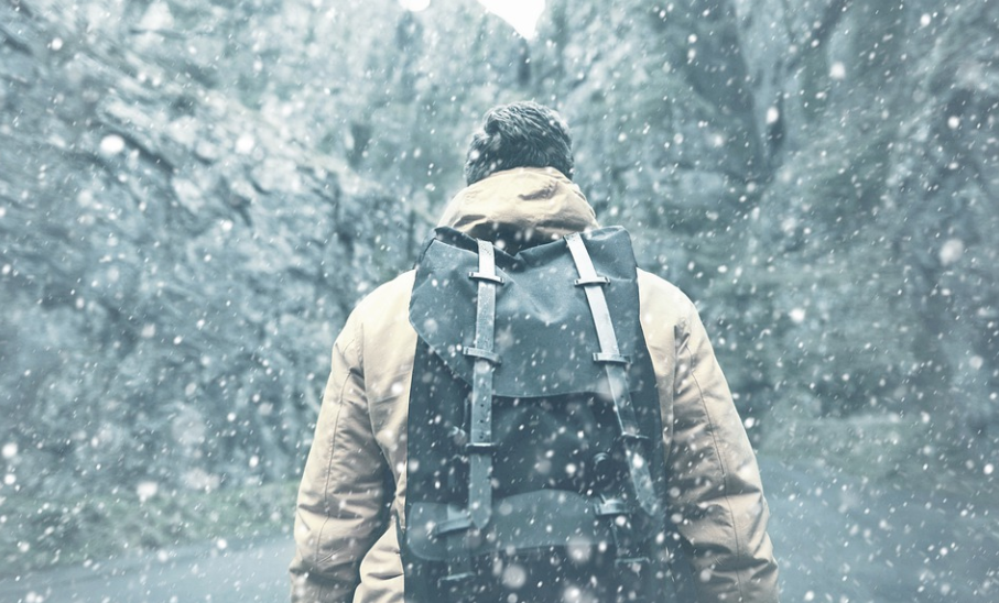 man with his backpack on a snow